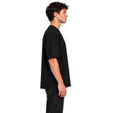 DAWIS Core black oversized cotton t-shirt with a relaxed fit worn by a man in a side profile view