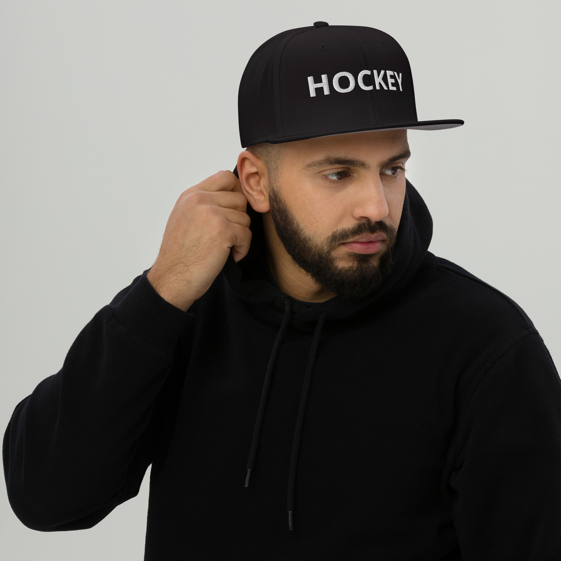HOCKEY Snapback-Cap in black worn by model, showcasing structured high-profile design.